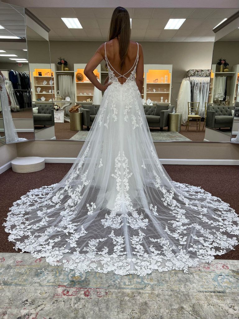 bride wearing open back bridal gown in store