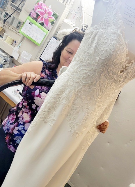 bridal stylist at Aurora Bridal making alterations to bridal dress