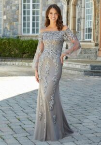 Stunning Mother of the Bride wearing an off the shoulder, silver formal dress.