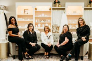 Aurora Bridal Boutique bridal stylist team seated in their fitting room.