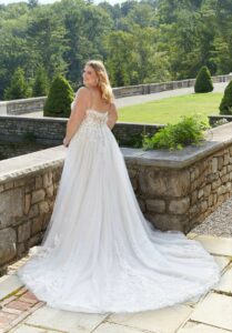 Plus Size bride wearing wedding dress from Aurora Bridal Boutique and smiling.