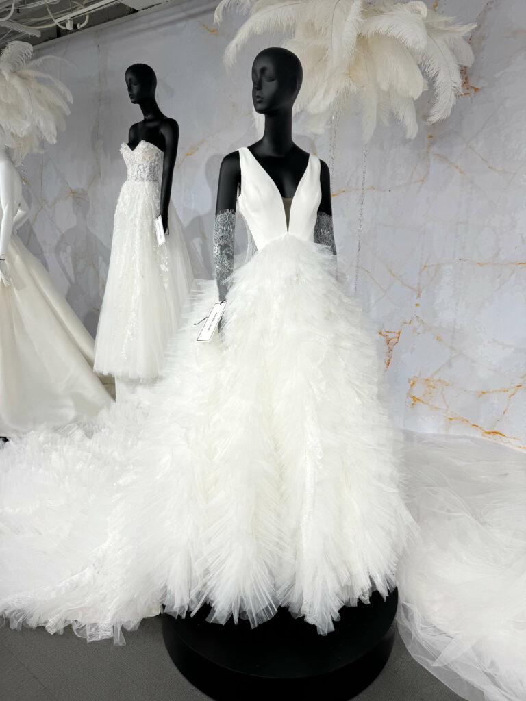 mannequins dressed with deep vee wedding dress with billowy skirt and train