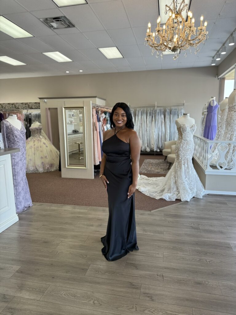 woman wearing a black bridesmaid dress in a Florida-based wedding shop.