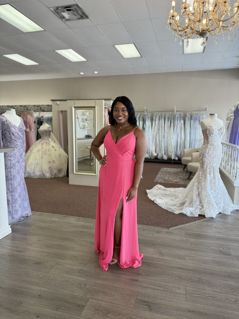 Bridesmaid in a colorful dress posing in a Florida wedding boutique