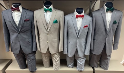 four suits with tuxedo bow ties modeled by mannequins at Aurora Bridal in Mims, Florida