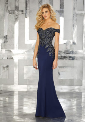 A woman modeling a stunning navy blue mother of the bride dress