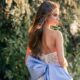 A wedding dress with blue floral decorations and a large blue bow on the back