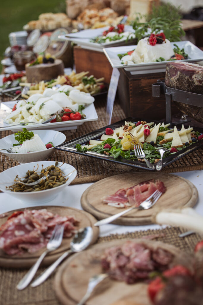 Rustic display of Italian wedding food, featuring fresh cheeses, meats, fruits, and vibrant salads.