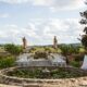 Outdoor wedding ceremony setup in an Italian villa garden, featuring a lily pond, floral arrangements, and scenic countryside views.