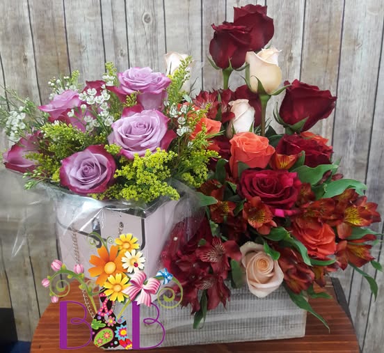 A beautifully arranged floral bouquet featuring lavender, peach, and deep red roses with greenery in an elegant vase, placed against a rustic wooden background.