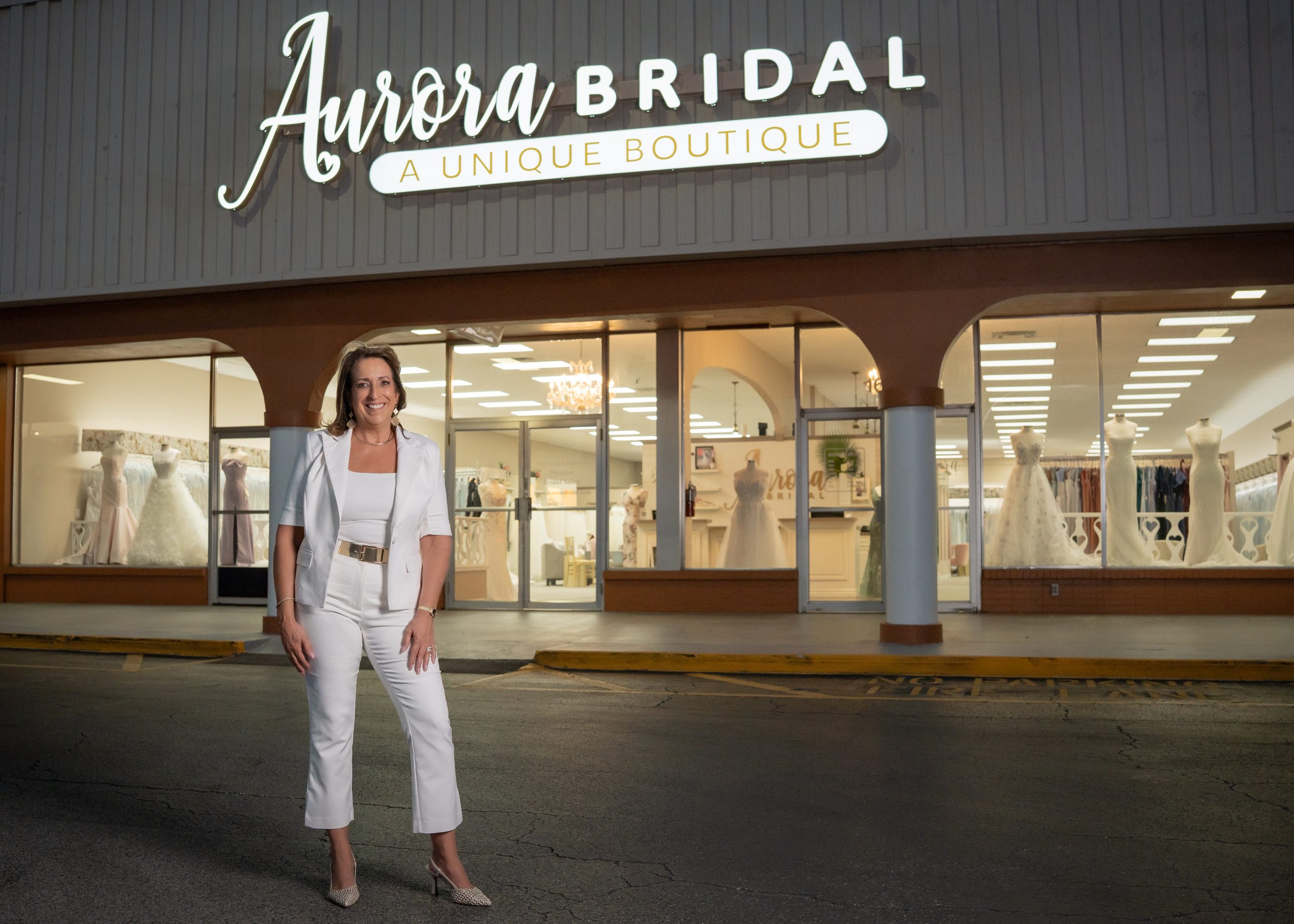 Cami Hester, the owner is standing by the facade of her bridal store, the Aurora Bridal.
