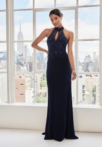 A midnight blue halter dress with lace embellishment on the top.