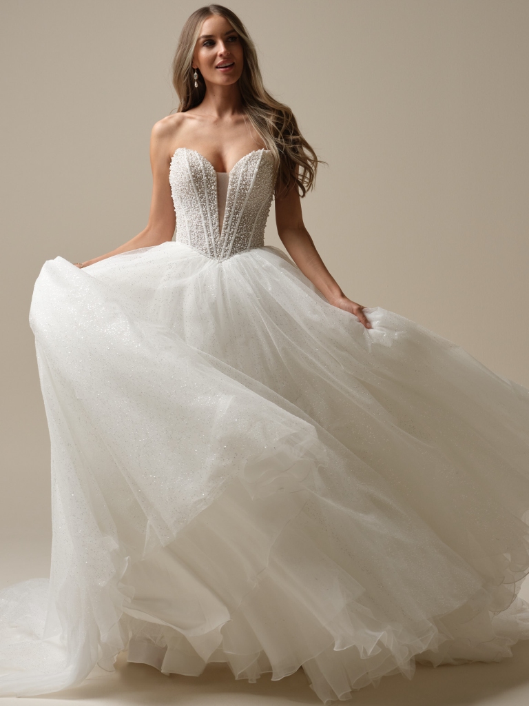 A bride twirls in a sparkling strapless ball gown with a beaded bodice and voluminous layered tulle skirt.