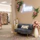 A cozy seating area inside a bridal shop featuring sofas, decorative pillows, and a glowing wall sign.